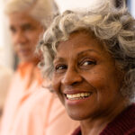 Close-up portrait of cheerful african american senior woman with multiracial friends in nursing home. Happy, unaltered, friendship, togetherness, support, assisted living and retirement concept.