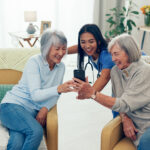 Happy nurse, elderly women and laughing with phone for funny joke, entertainment or streaming at ol.