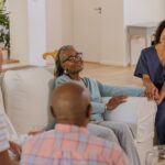In living room, caregiver engaging with senior friends, sharing joyful conversation. Caregiving, companionship, friendship, elderly, support, togetherness